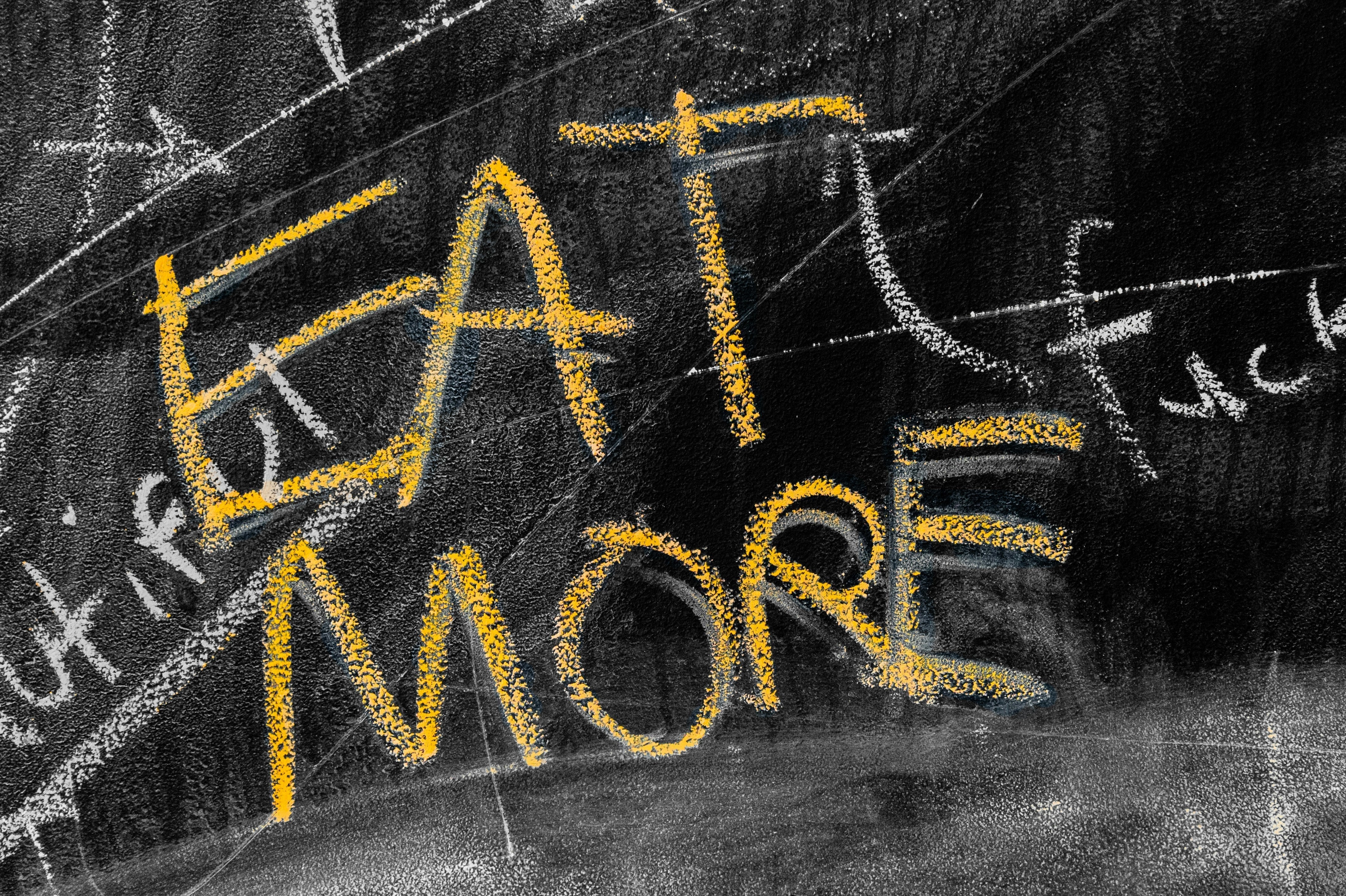Eat more written in yellow chalk on a blackboard, representing a planned diet break at maintenance calories.