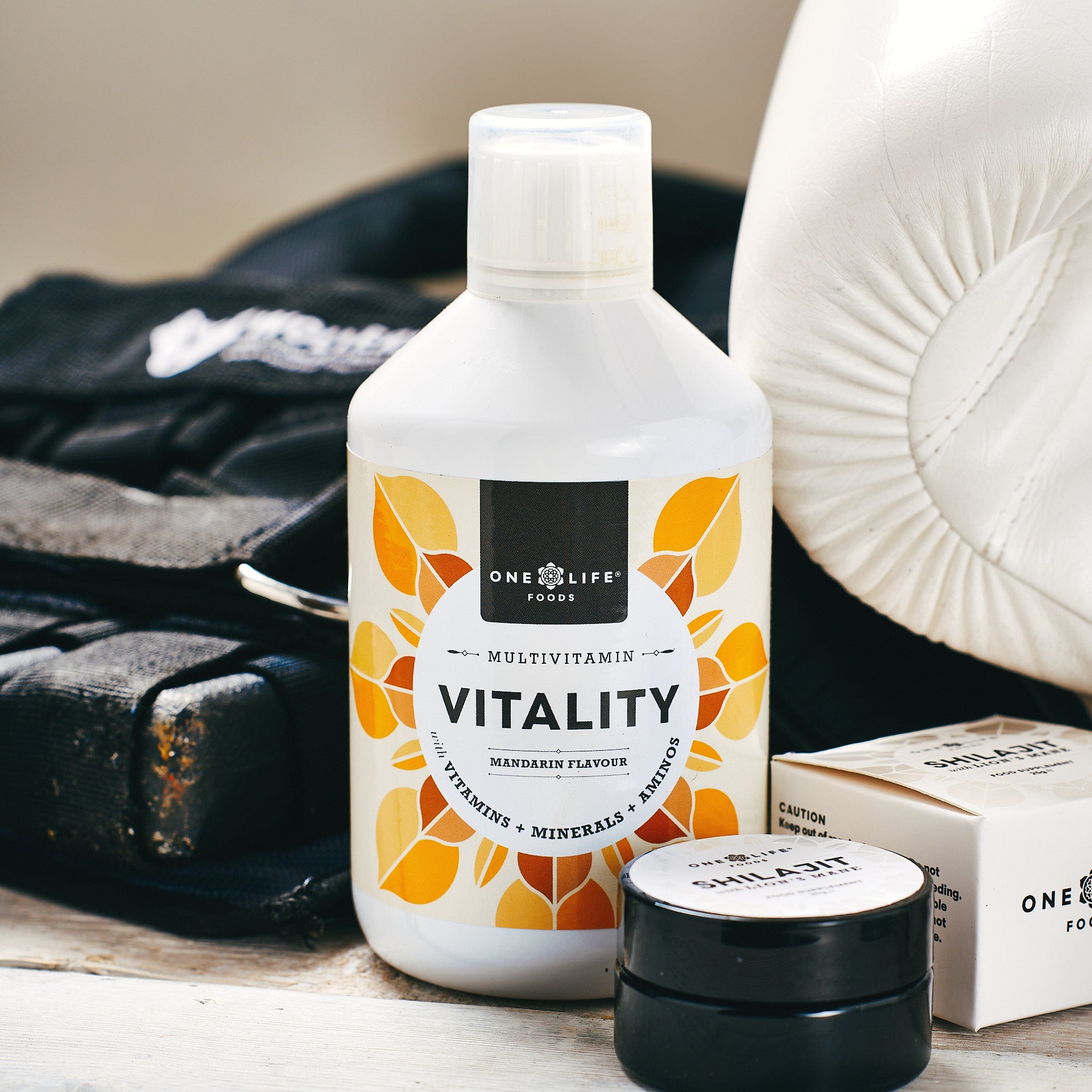 Vitality liquid multivitamin bottle with boxing glove, weighted vest and  One Life Foods products